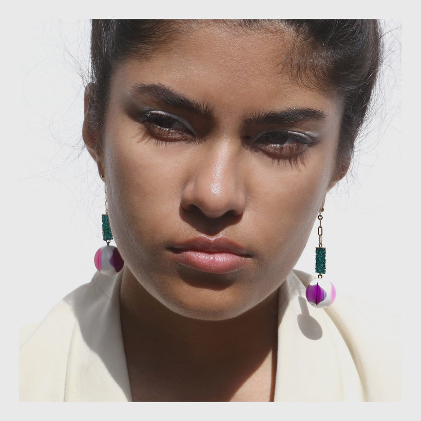 Green crystal column earrings with purple orb drop.